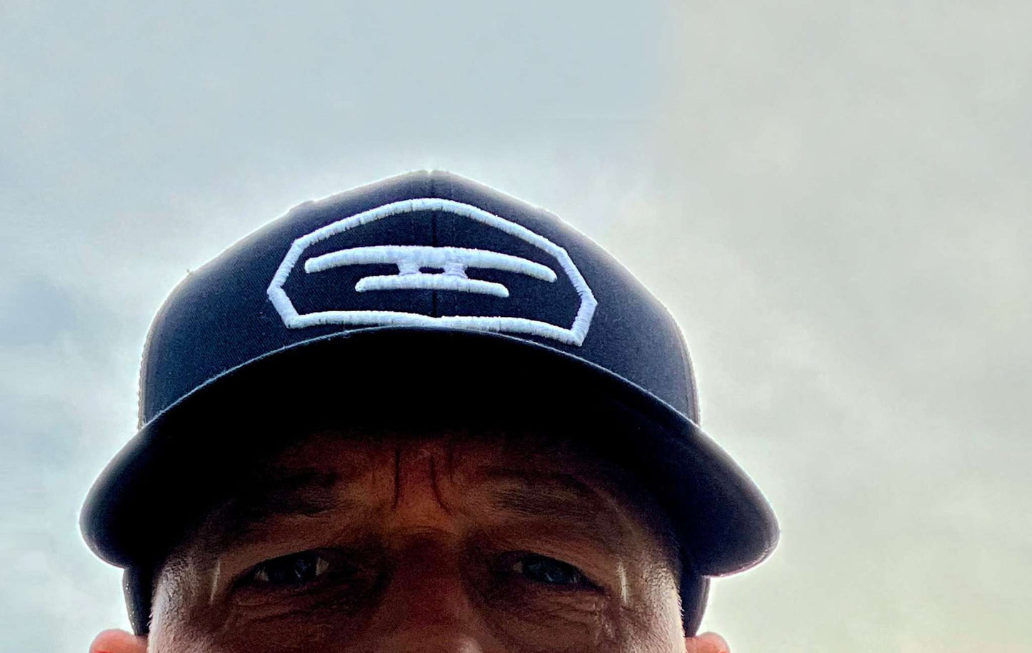 Navy blue cap with Klēt puff embroidered patch logo on front