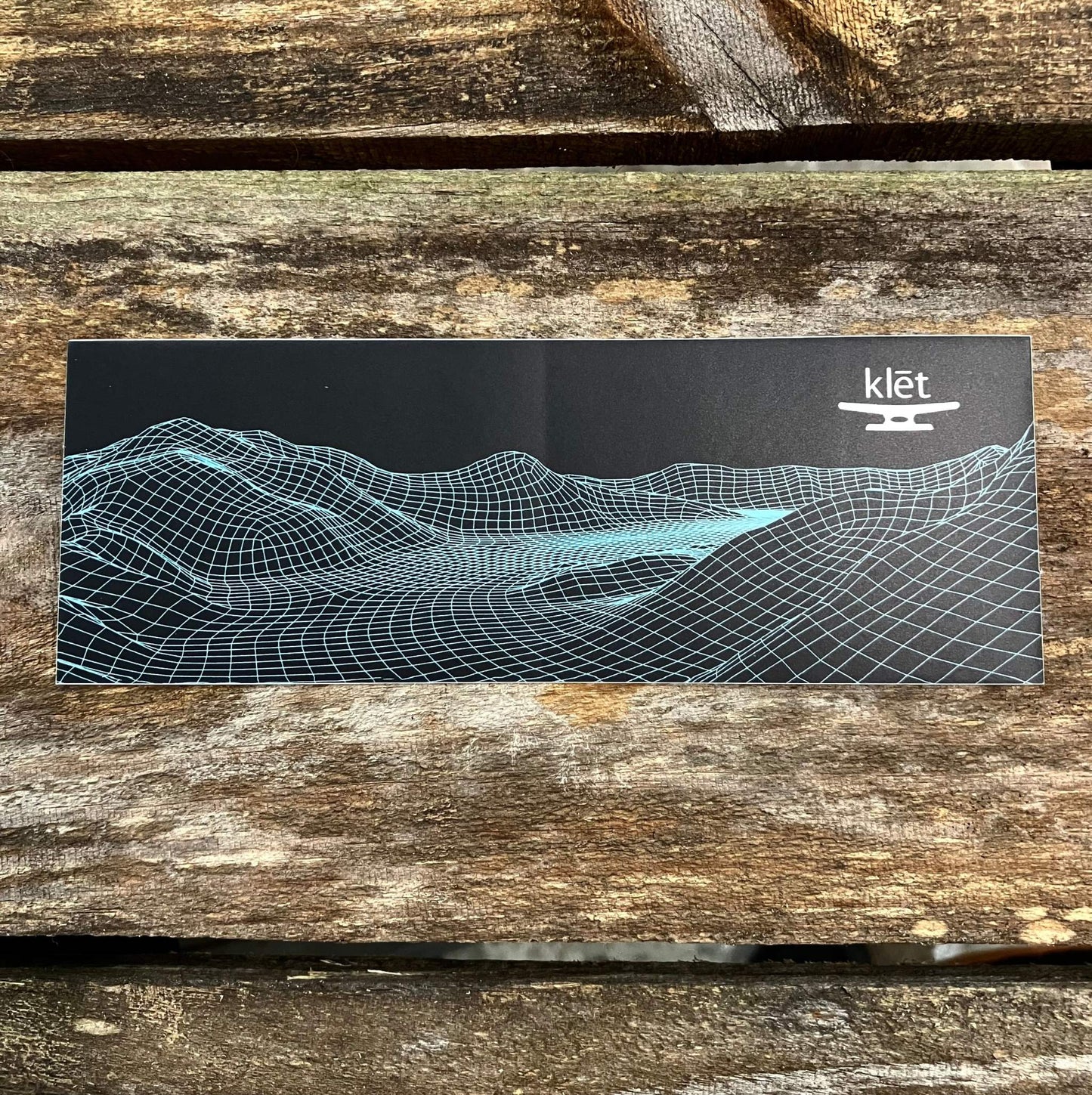 Klēt Middle Grounds 7-inch sticker with blue digital wireframe landscape design on black background