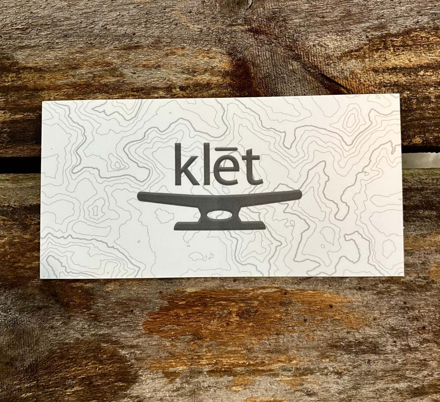 Klēt TopoMap 5 inch sticker with contour map design on wooden background Klēt - TopoMap Sticker