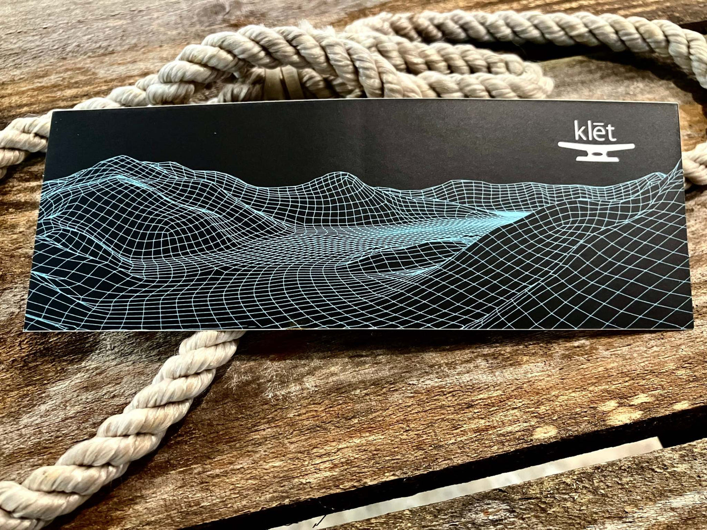 7-inch Klēt Middle Grounds sticker with blue wireframe landscape design on black background