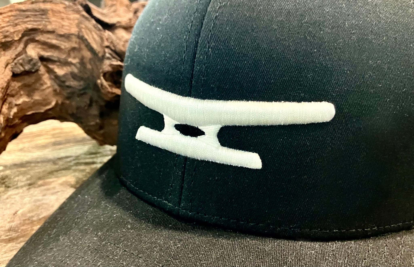 Black cap with white puff embroidered Klēt monogram logo on front panel