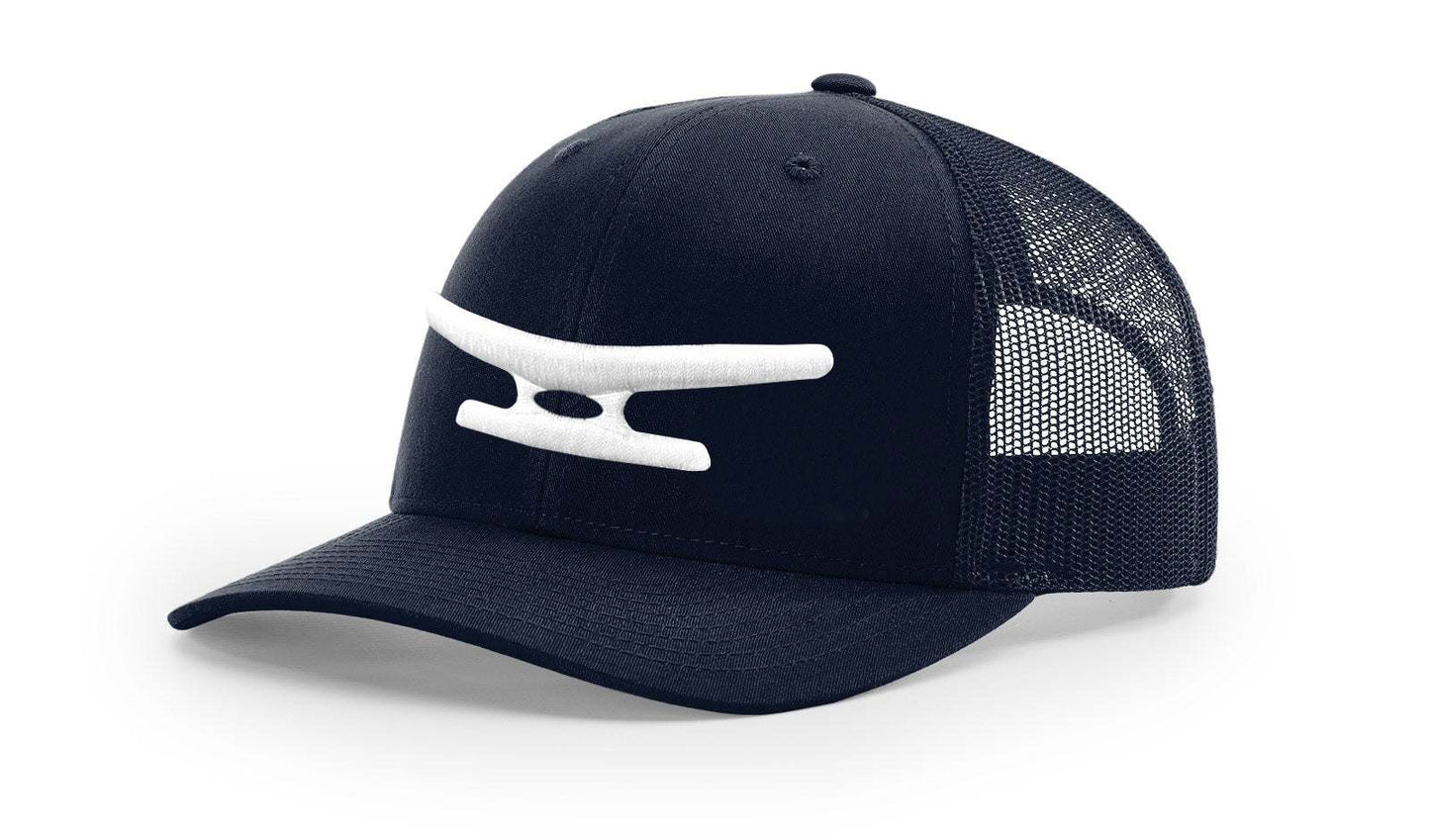 Black mesh trucker cap with white puff embroidered Klēt monogram logo on front panel