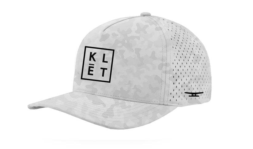 White Klēt BOCA Snapback cap with subtle camouflage pattern and black logo on front panel, featuring structured fit and perforated side panels.