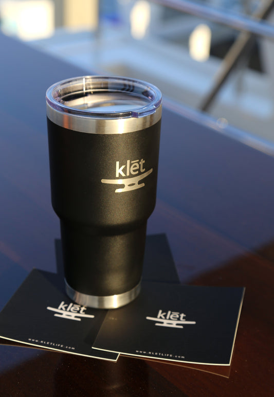 Black Klēt - Side Kick Tumbler with clear lid on wooden table with Klēt branded cards