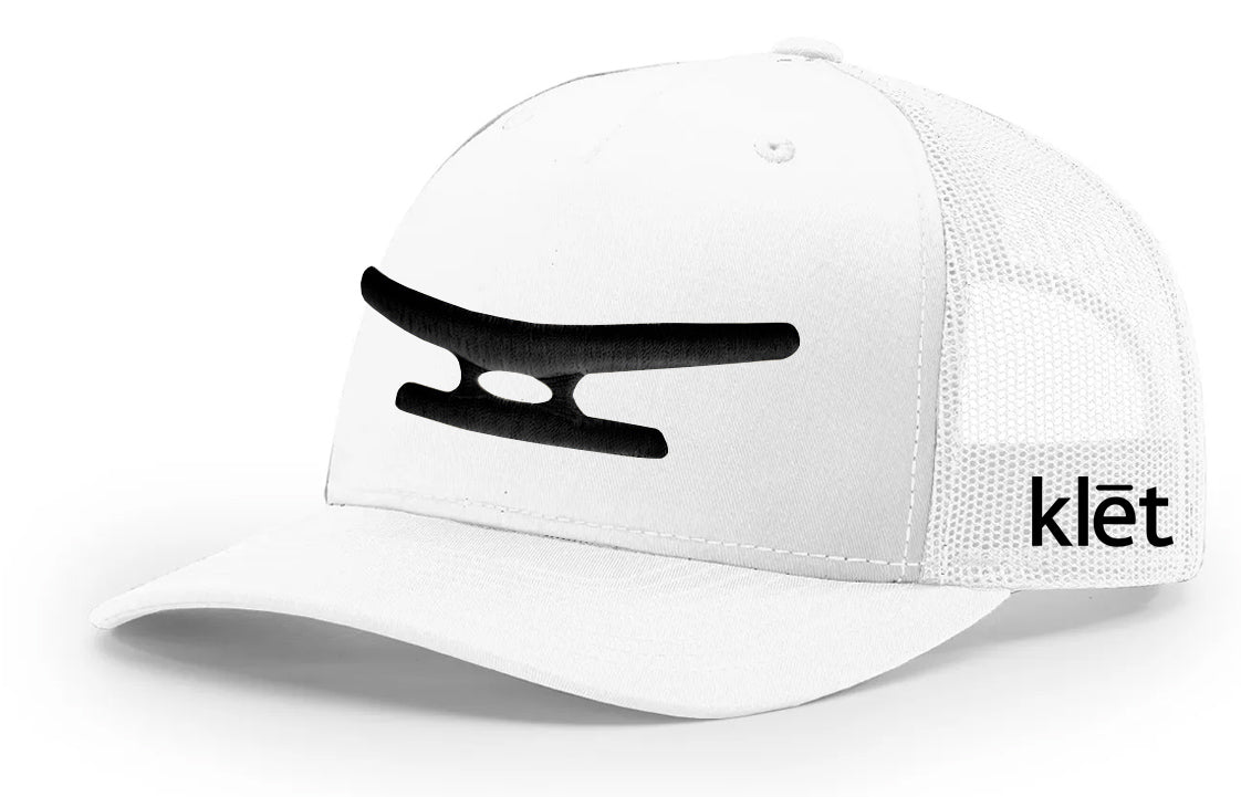 Klēt Monogram puff embroidery on white fabric adding textured, sophisticated style